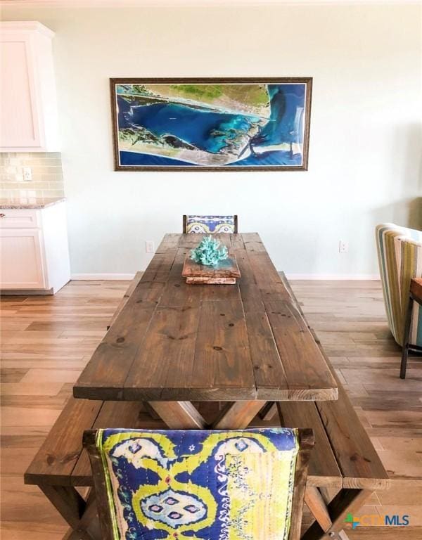 dining room with light wood finished floors and baseboards