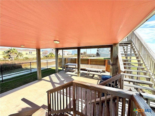 view of patio with fence and stairway