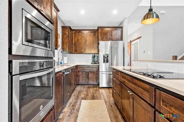 4130 Cripple Creek Dr, Temple, TX 76502 - kitchen featuring stainless steel appliances, wood finished floors, backsplash, light countertops, and decorative light fixtures