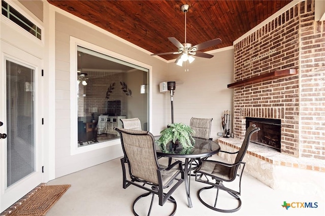 view of patio with an outdoor brick fireplace and ceiling fan