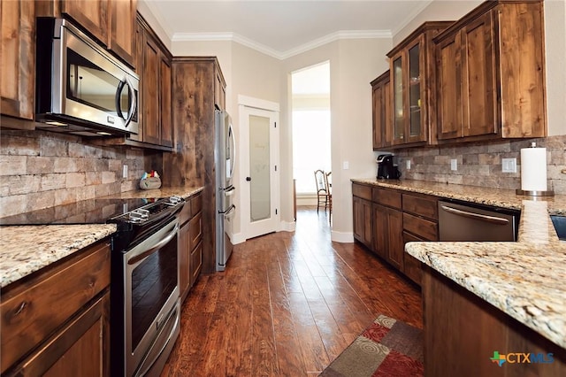 kitchen featuring stainless steel appliances, ornamental molding, dark hardwood / wood-style floors, and light stone counters