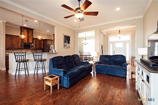 living room featuring ornamental molding, dark hardwood / wood-style floors, and ceiling fan with notable chandelier