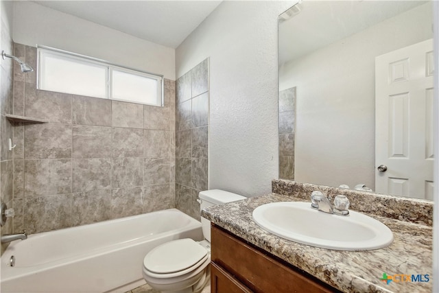 full bathroom featuring vanity, tiled shower / bath combo, and toilet