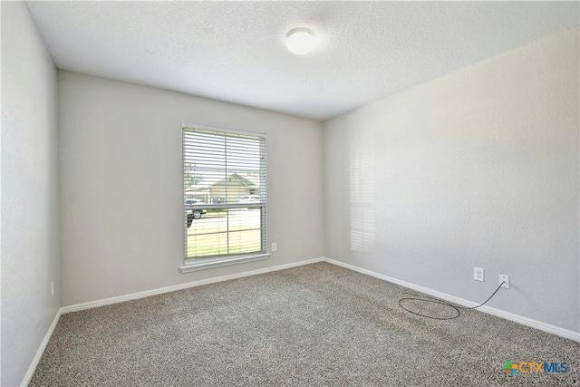 carpeted empty room with a textured ceiling