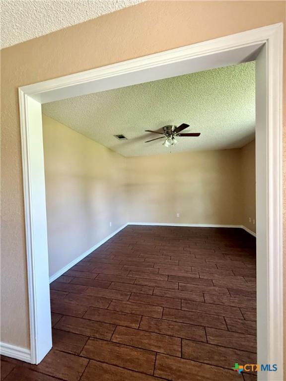 3002 Lois Cir, Copperas Cove, TX 76522 - unfurnished room featuring a ceiling fan, a textured ceiling, and dark wood-style flooring