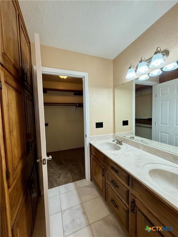 3002 Lois Cir, Copperas Cove, TX 76522 - full bath with double vanity, a spacious closet, a textured ceiling, and tile patterned flooring