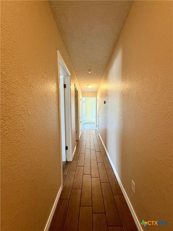 3002 Lois Cir, Copperas Cove, TX 76522 - corridor featuring a textured wall, wood finished floors, and a textured ceiling