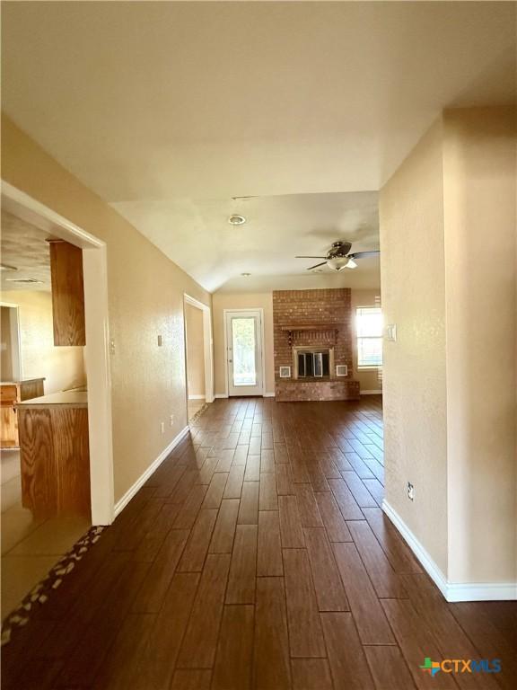 3002 Lois Cir, Copperas Cove, TX 76522 - unfurnished living room with ceiling fan, dark wood-type flooring, and a brick fireplace