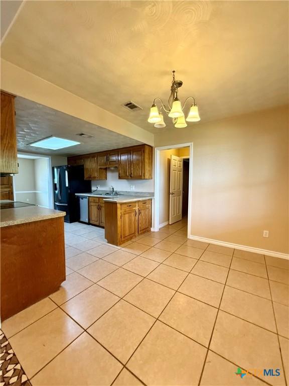 3002 Lois Cir, Copperas Cove, TX 76522 - kitchen featuring black refrigerator with ice dispenser, a chandelier, light countertops, and light tile patterned flooring
