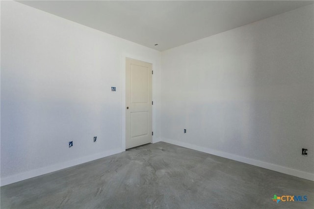 unfurnished room with concrete flooring