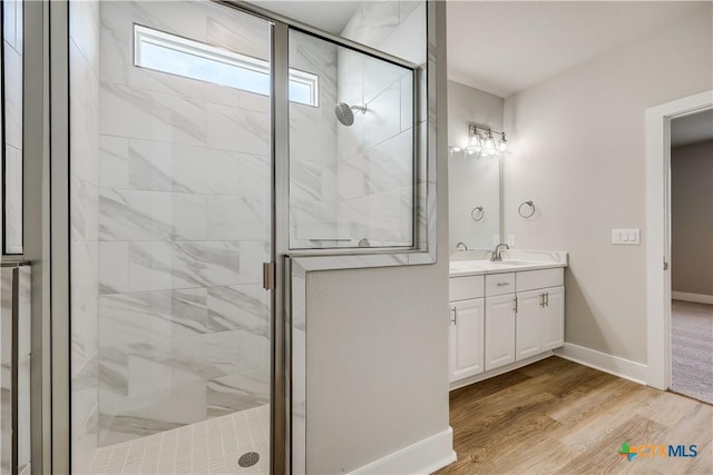 bathroom with hardwood / wood-style flooring, vanity, and an enclosed shower