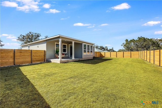 back of property featuring a patio area, a fenced backyard, and a yard