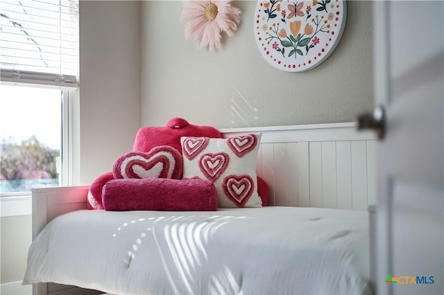 bedroom featuring a wainscoted wall