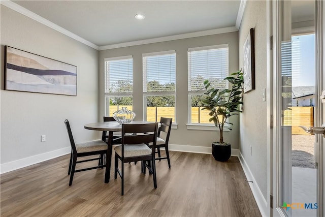 dining room with baseboards, wood finished floors, and crown molding