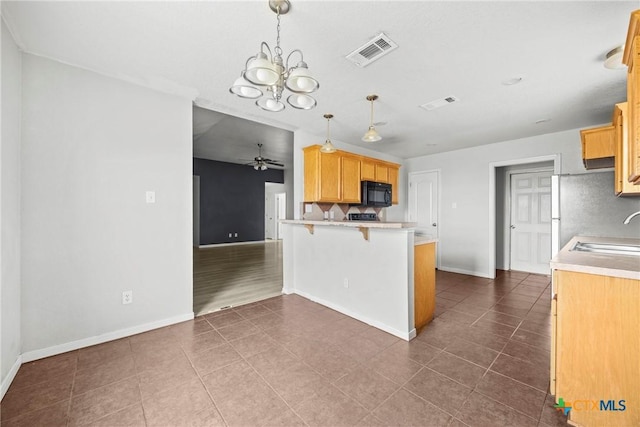 1212 Trailboss Dr, Killeen, TX 76549 - kitchen featuring black microwave, a peninsula, light countertops, a ceiling fan, and a chandelier
