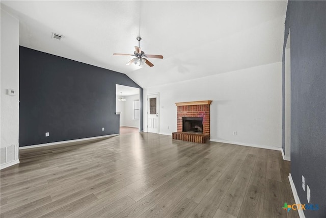 1212 Trailboss Dr, Killeen, TX 76549 - unfurnished living room featuring ceiling fan, lofted ceiling, wood finished floors, a fireplace, and a chandelier