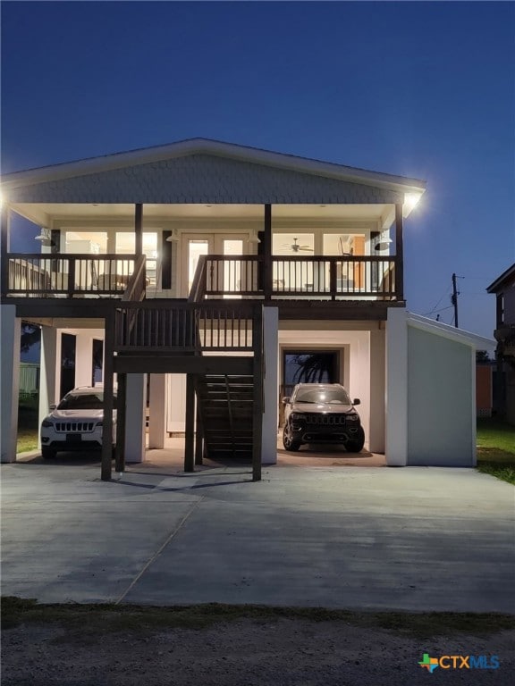 back of property featuring a carport, stairs, and concrete driveway