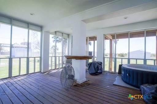 sunroom / solarium featuring wood-type flooring and a wooden deck