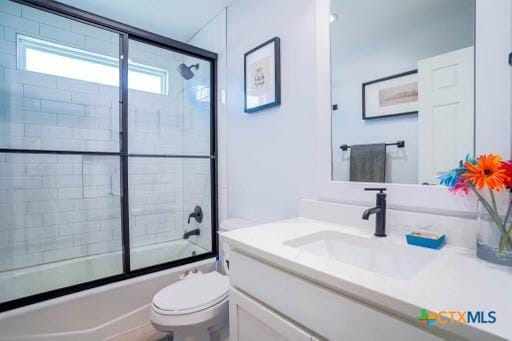 full bath featuring toilet, vanity, and enclosed tub / shower combo