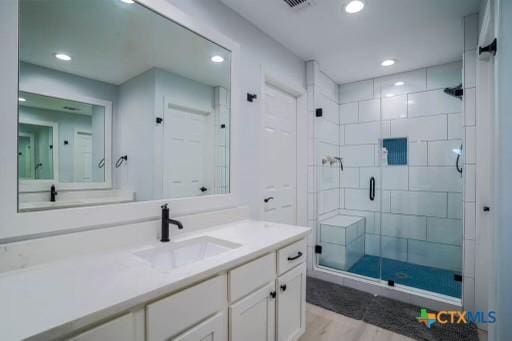 bathroom with recessed lighting, vanity, and a stall shower