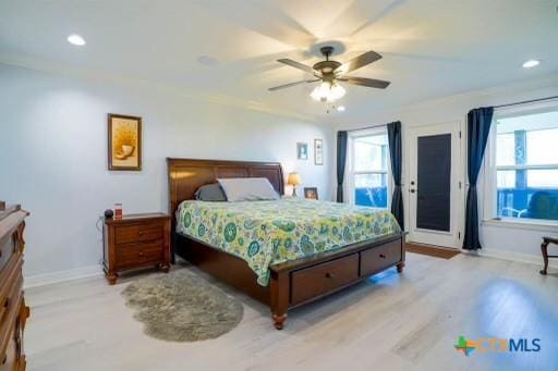 bedroom with multiple windows, baseboards, and wood finished floors