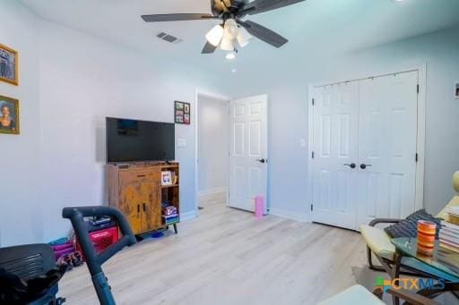 interior space with visible vents, baseboards, a ceiling fan, and wood finished floors