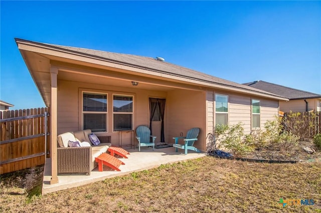 rear view of house featuring a yard, outdoor lounge area, and a patio area