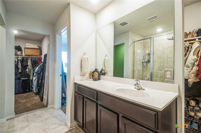 bathroom featuring vanity, a shower with shower door, and tile patterned floors