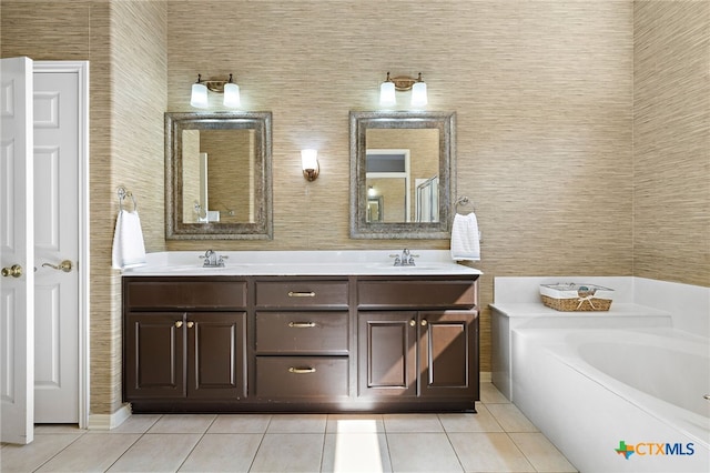 bathroom with a bathing tub, vanity, and tile patterned floors