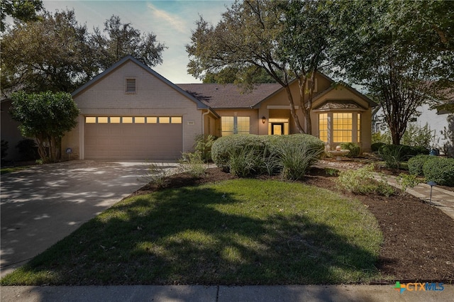 view of front of house featuring a garage and a front yard