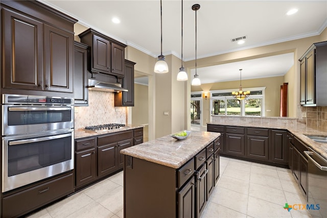 kitchen featuring crown molding, appliances with stainless steel finishes, dark brown cabinets, pendant lighting, and a center island