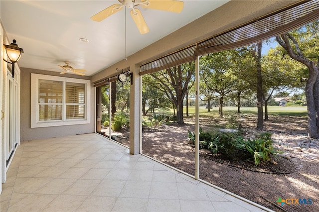 unfurnished sunroom with ceiling fan