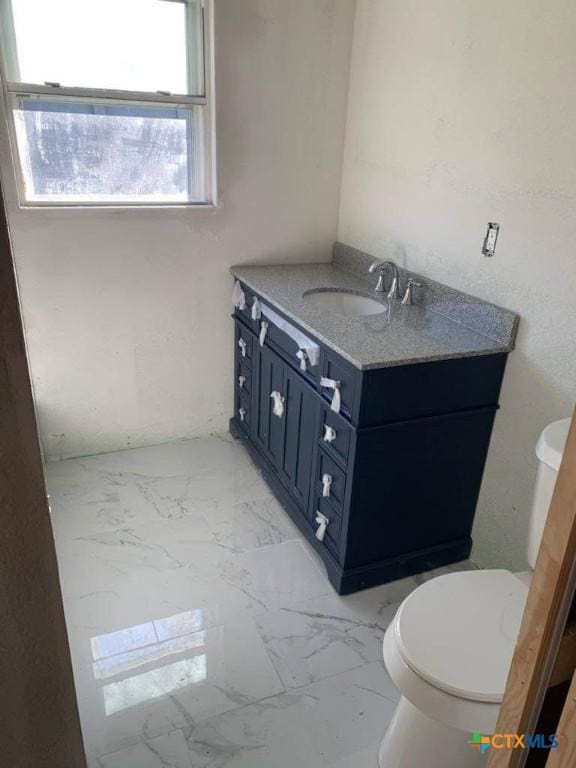 1202 S 7th St, Temple, TX 76504 - bathroom with vanity, toilet, and marble finish flooring