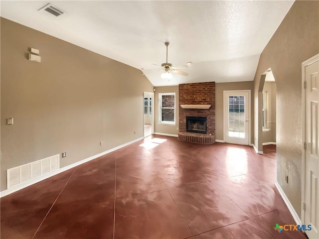 unfurnished living room featuring a brick fireplace, vaulted ceiling, and ceiling fan