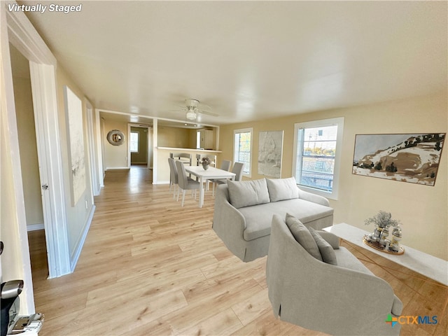 living room with ceiling fan and light hardwood / wood-style floors