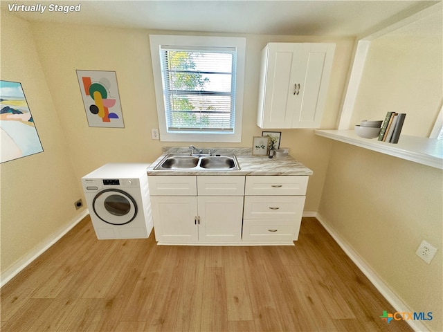 washroom featuring cabinets, washer / dryer, sink, and light hardwood / wood-style flooring