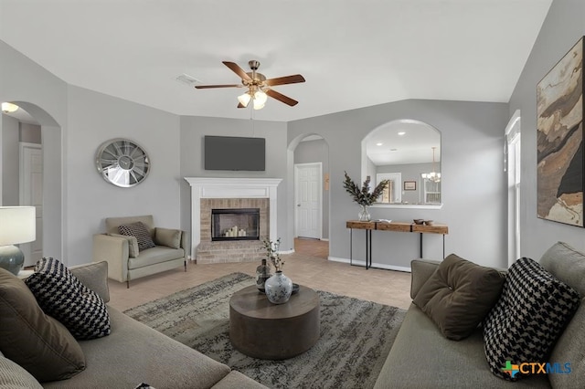 9511 Raeburn Ct, Killeen, TX 76542 - tiled living room featuring a ceiling fan, arched walkways, and a brick fireplace