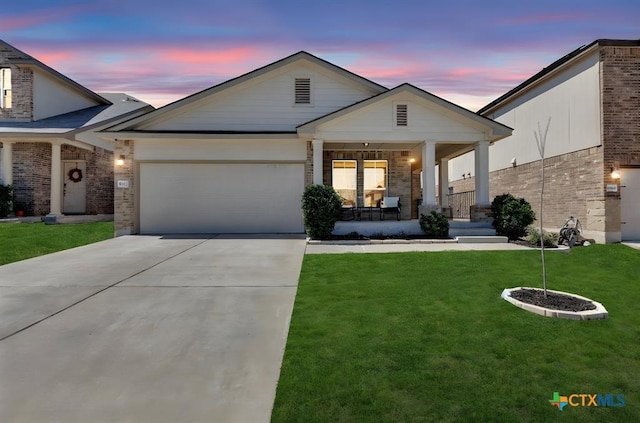 view of front of house with an attached garage, a front lawn, brick siding, a porch, and driveway