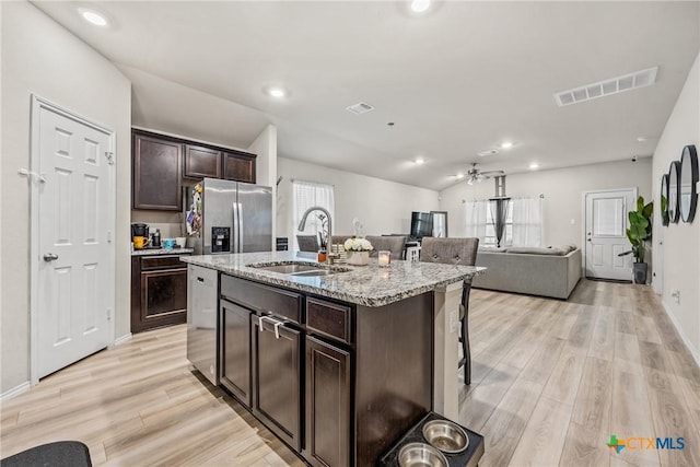 8919 Cantera Ridge Rd, Temple, TX 76502 - kitchen featuring stainless steel appliances, light wood-style floors, open floor plan, dark brown cabinetry, and a kitchen breakfast bar