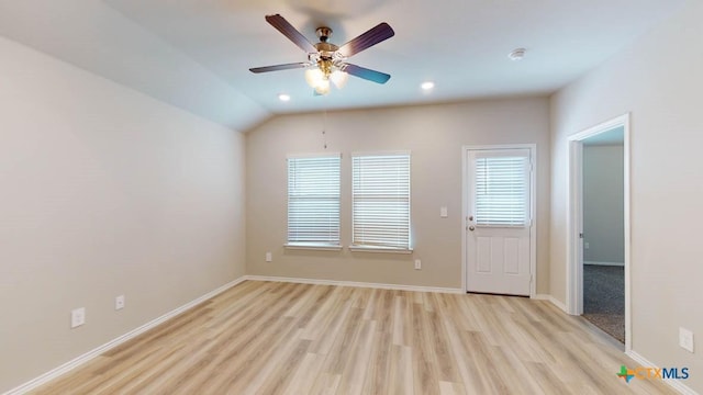 unfurnished room featuring ceiling fan, vaulted ceiling, and light wood-type flooring