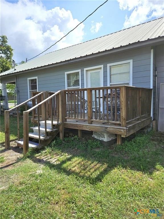 rear view of property with a lawn and a deck