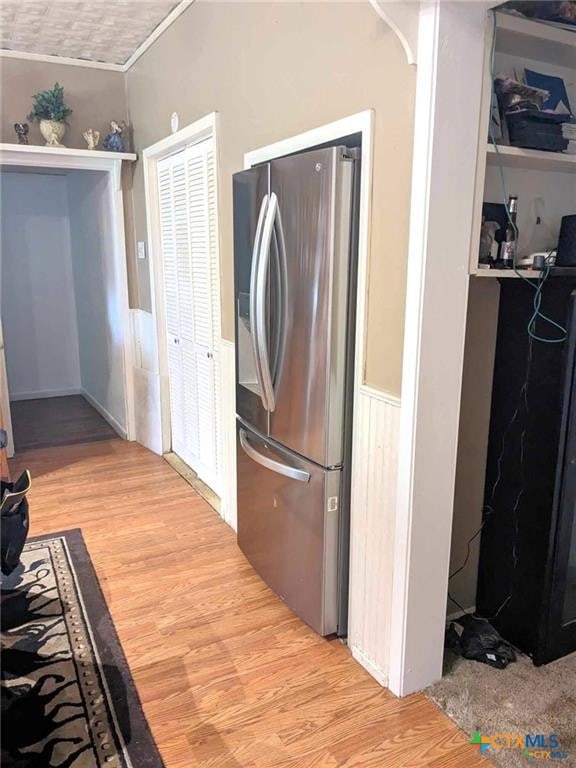 laundry area featuring light wood-type flooring and ornamental molding