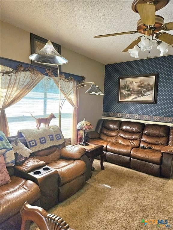 living room with a textured ceiling, ceiling fan, and carpet floors