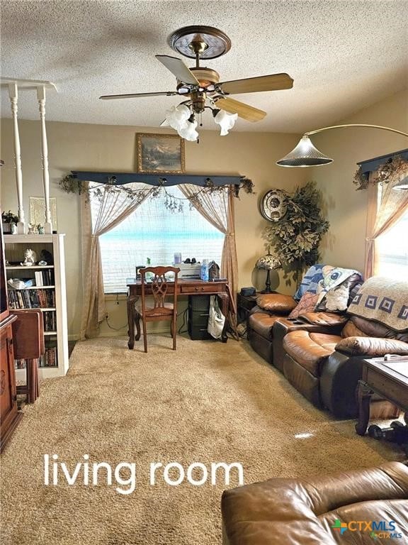 carpeted living room with ceiling fan and a textured ceiling