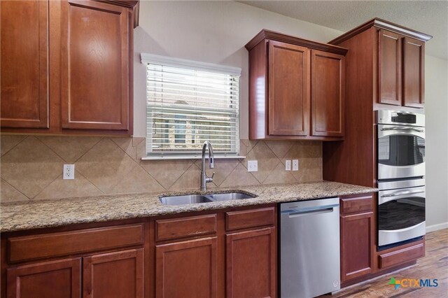3903 Scenic Trail Dr, Harker Heights, TX 76548 - kitchen with appliances with stainless steel finishes, a sink, backsplash, and light stone countertops