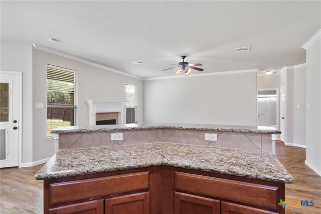 3903 Scenic Trail Dr, Harker Heights, TX 76548 - kitchen featuring light wood finished floors, ceiling fan, crown molding, light stone countertops, and open floor plan
