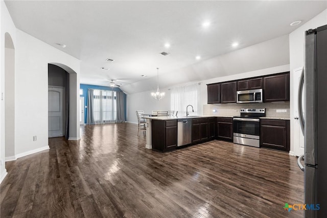 865 Stockdale Rd, Copperas Cove, TX 76522 - kitchen featuring appliances with stainless steel finishes, open floor plan, a peninsula, arched walkways, and dark brown cabinets