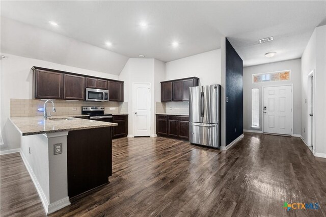865 Stockdale Rd, Copperas Cove, TX 76522 - kitchen with appliances with stainless steel finishes, a peninsula, dark brown cabinets, tasteful backsplash, and dark wood-style flooring