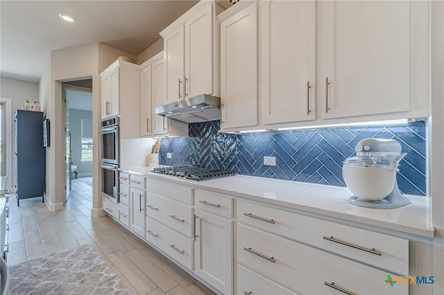 1308 Dancing Oak Ln, San Marcos, TX 78666 - kitchen featuring stainless steel appliances, under cabinet range hood, white cabinets, backsplash, and recessed lighting