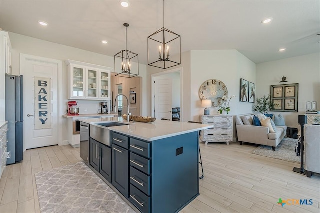 1308 Dancing Oak Ln, San Marcos, TX 78666 - kitchen featuring light wood-style floors, white cabinetry, light countertops, open floor plan, and freestanding refrigerator